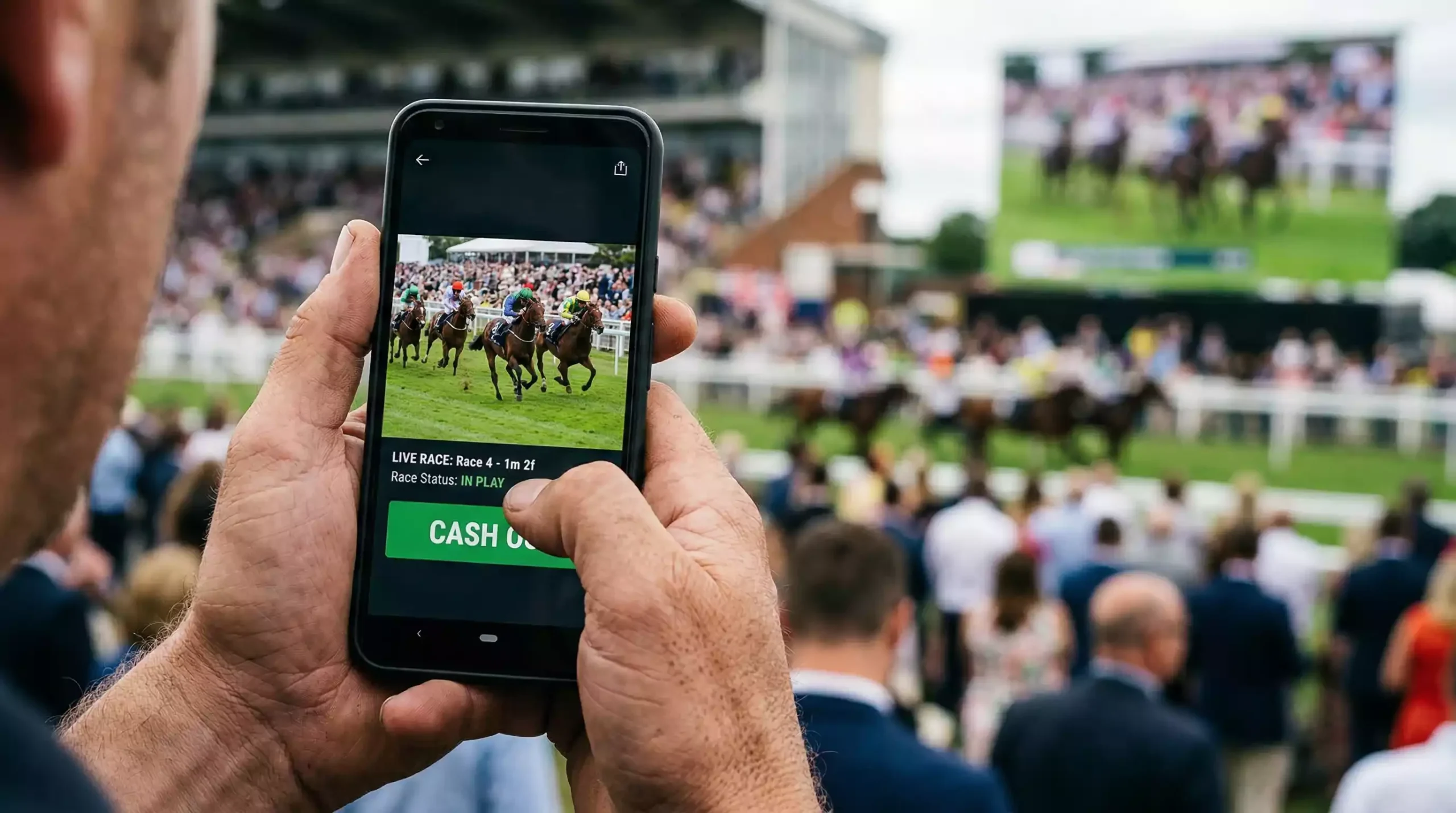 Person watching a live horse race on a phone with finger hovering over a button